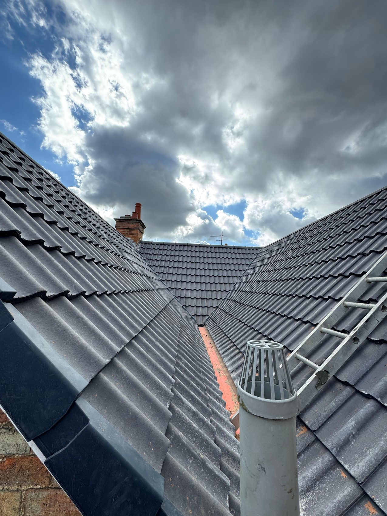 Finished grey tiled roof valley with new flue terminal, Bedford