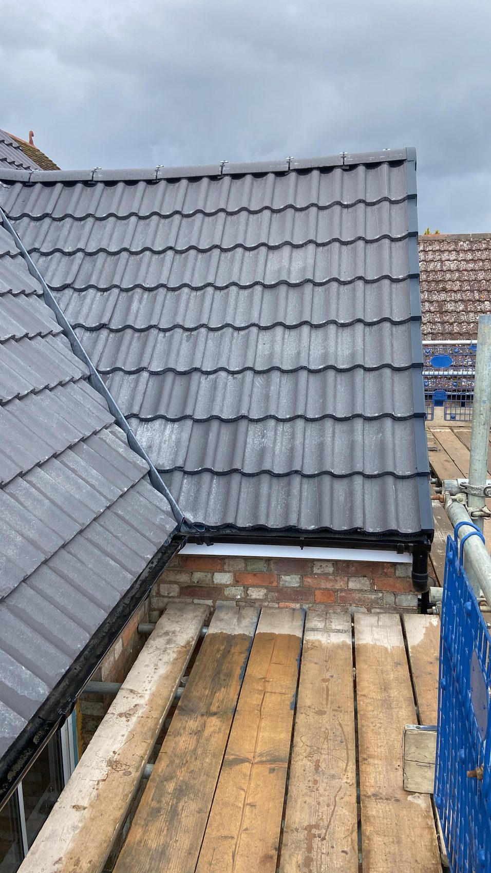 A full re-covered slope in new grey tiles with anthracite dry verge and new gutter at the eaves