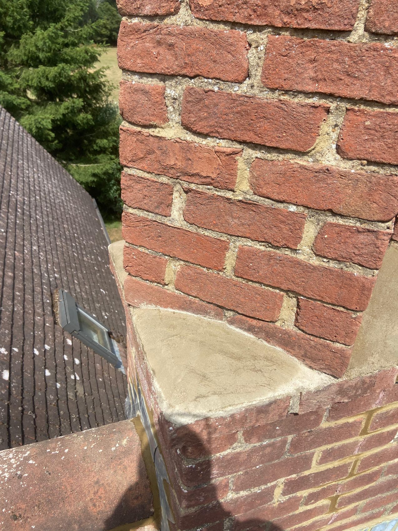 Repointed chimney brickwork with fresh flaunching on the offset