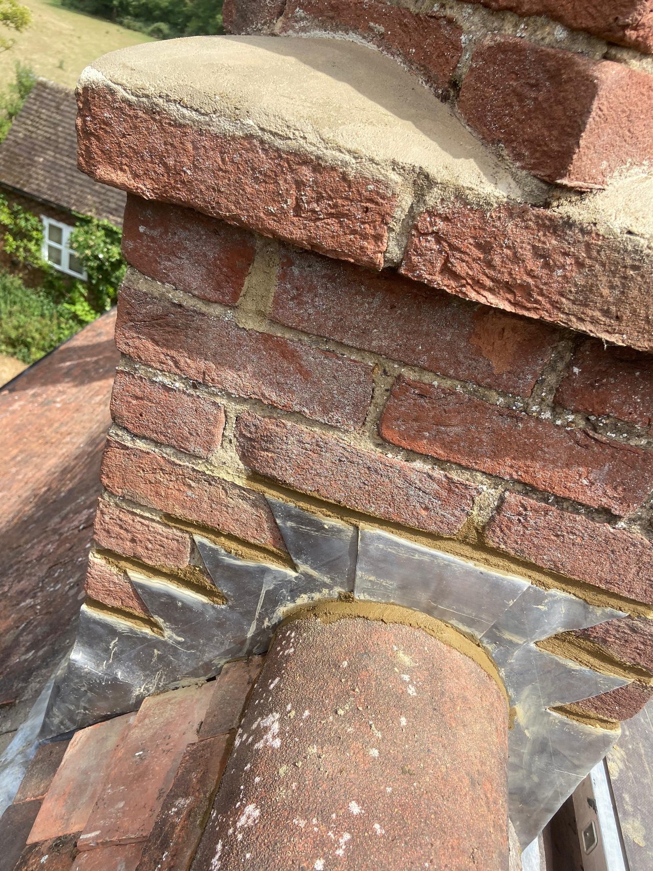 Re-flaunched chimney cap with new lead flashing and a re-bedded ridge tile below