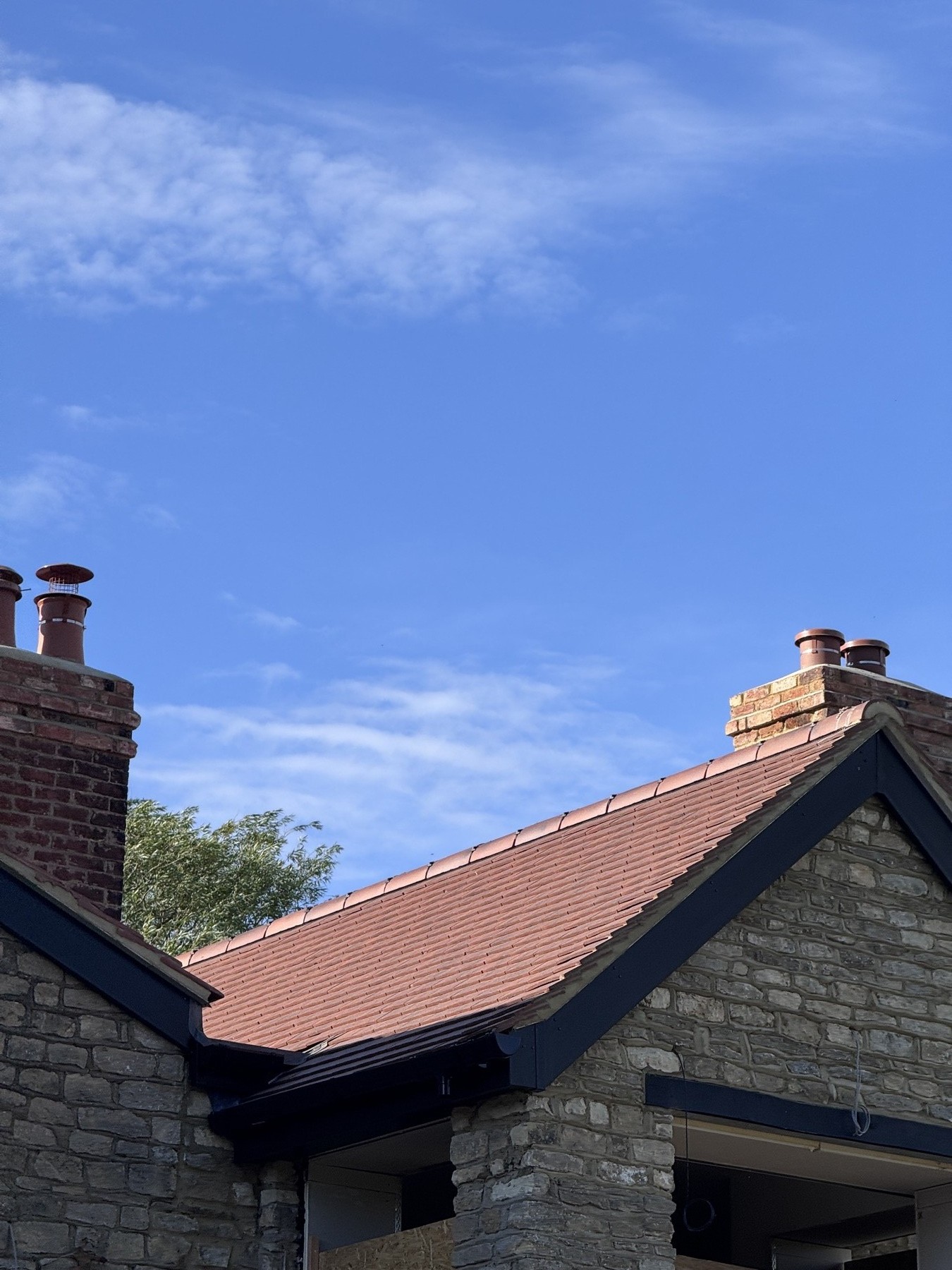 Fresh lead flashing to a chimney on a tiled roof