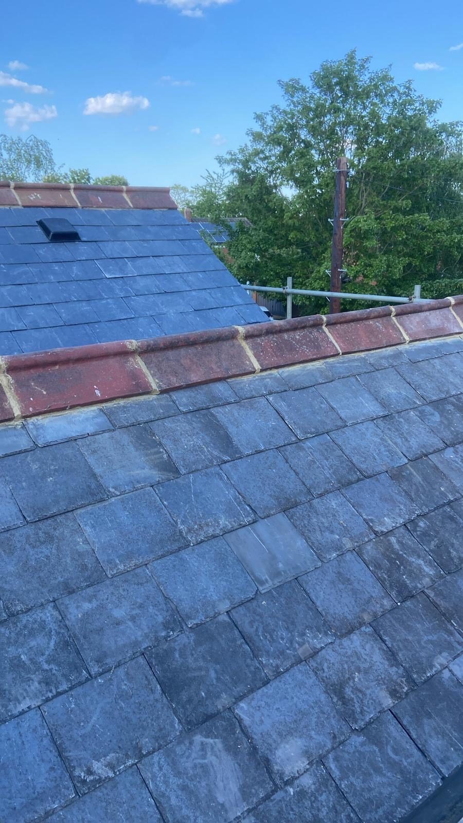 Finished slate slope with red clay ridge against blue sky