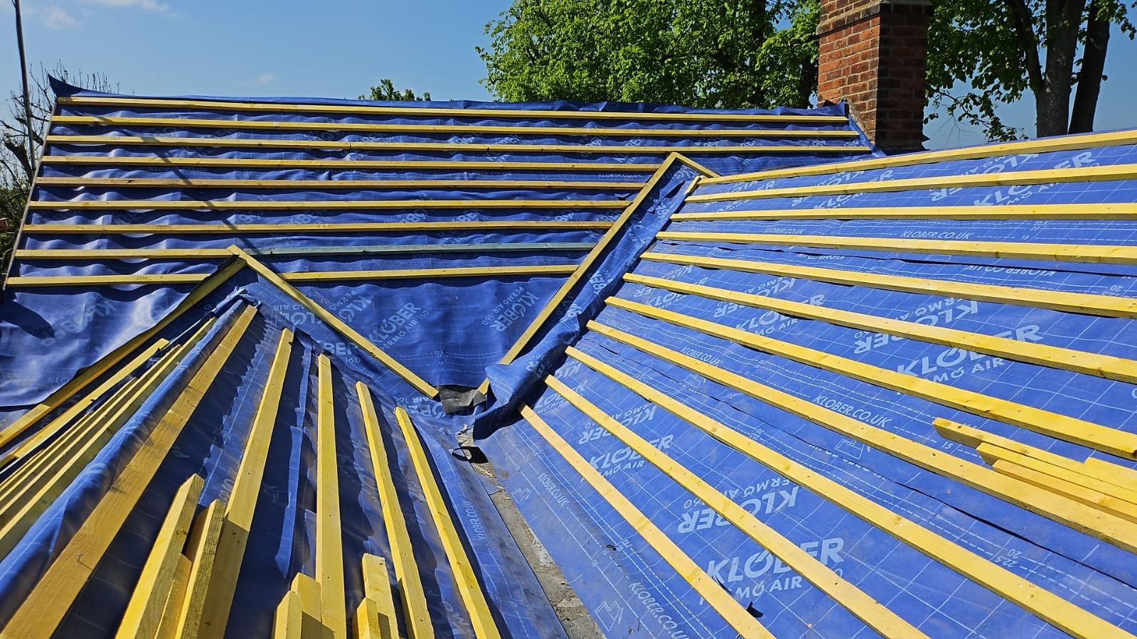 Roof slopes wrapped in blue breathable membrane with new battens over