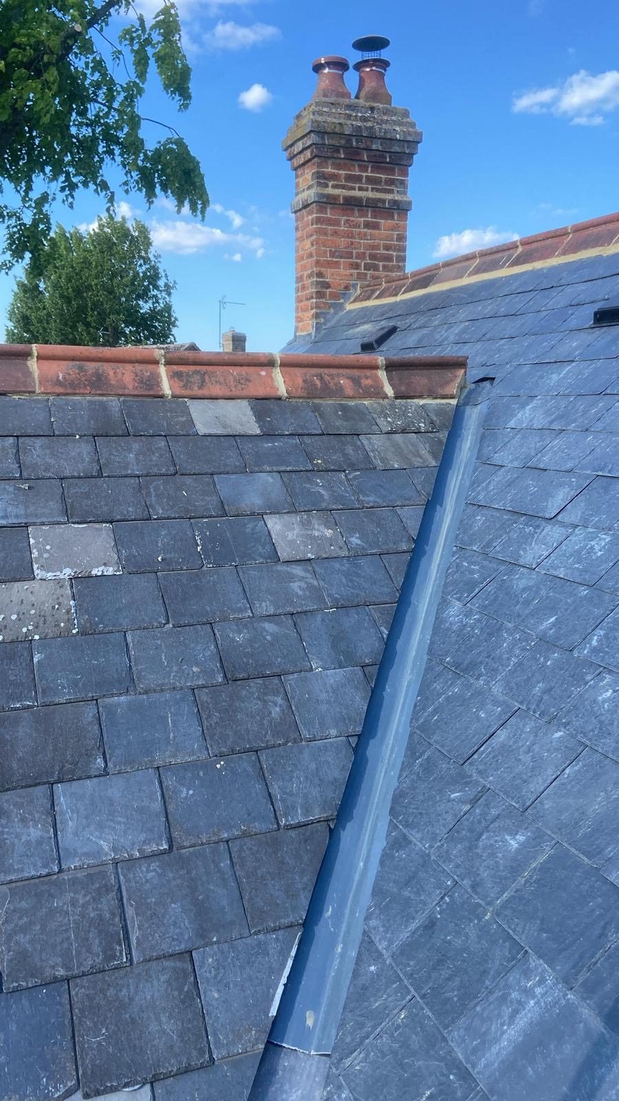 Finished slate roof with lead hip, red ridge and brick chimney
