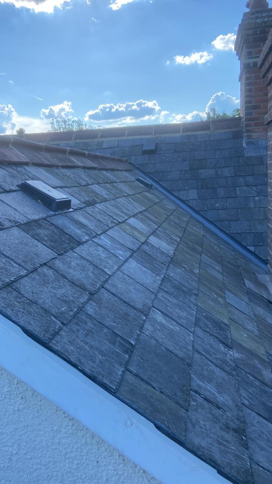 Finished slate slope with roof vent up to the red clay ridge