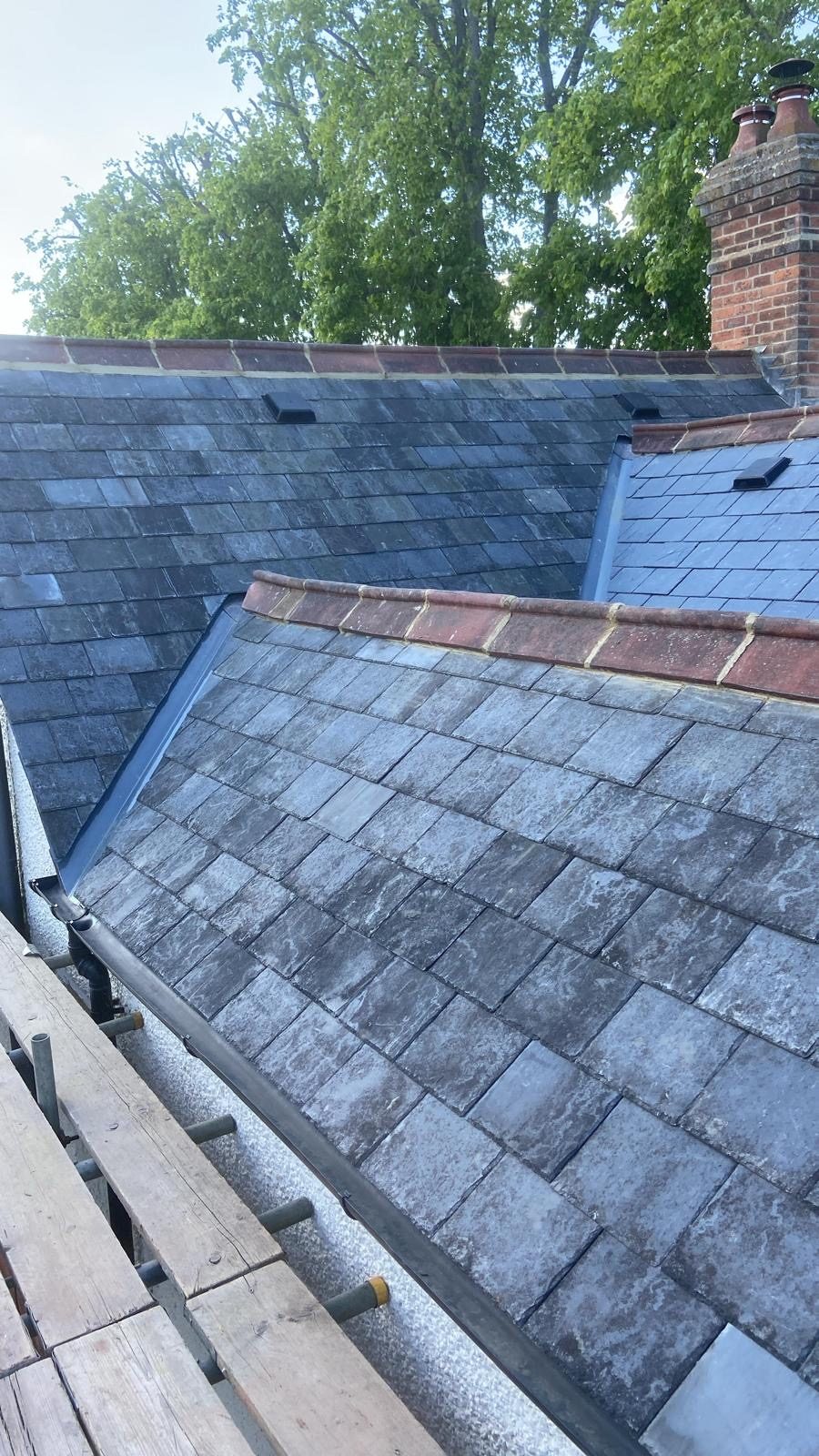 Several slopes of finished reclaimed slate with red clay ridges and a lead valley