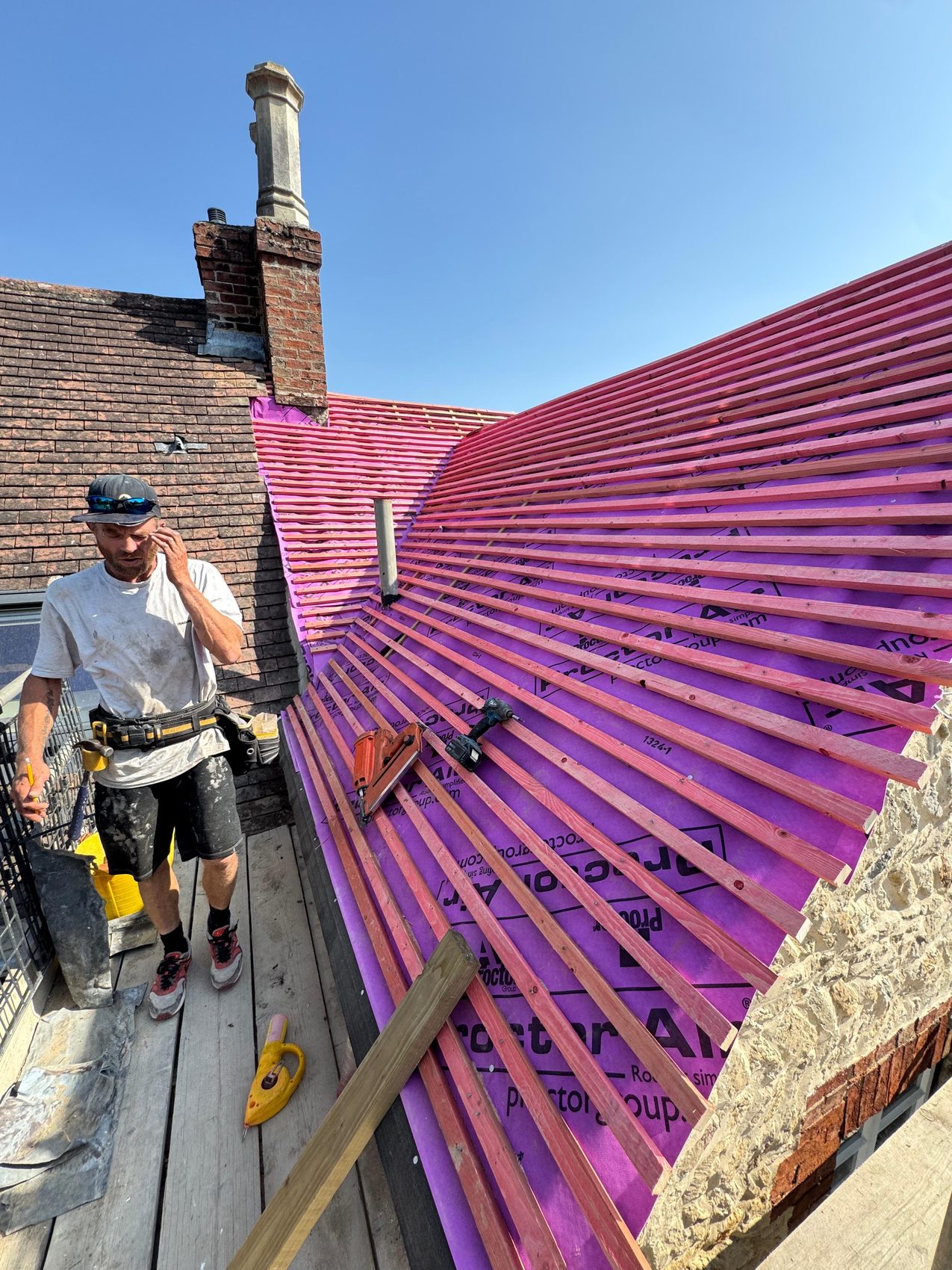 Roofer fixing treated battens to gauge over the breathable membrane